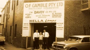 The founder Frank Davey, a gentlemen in his suit and a lady posing for a photo in front of F. W. Davey & Co's new shop that is now opened in Sydney, Australia, to increase the coverage of water pump sales.