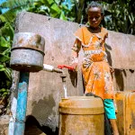 An Indian girl drawing hydration from a well, depicting this section meant for water pumps for well use.